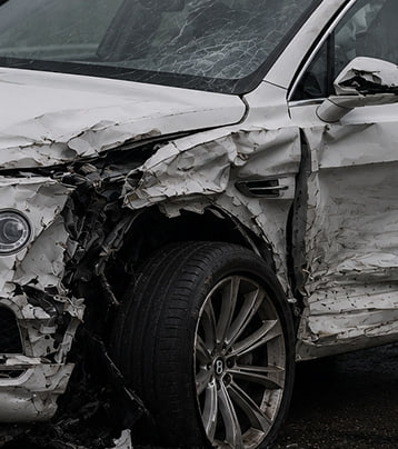 Bentley with visible front-left collision damage in a supplied before photograph