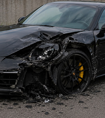 Porsche with visible front-left collision damage in a supplied before photograph