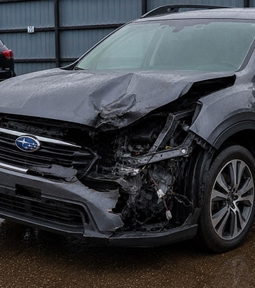 Subaru with visible front-left collision damage in a supplied before photograph