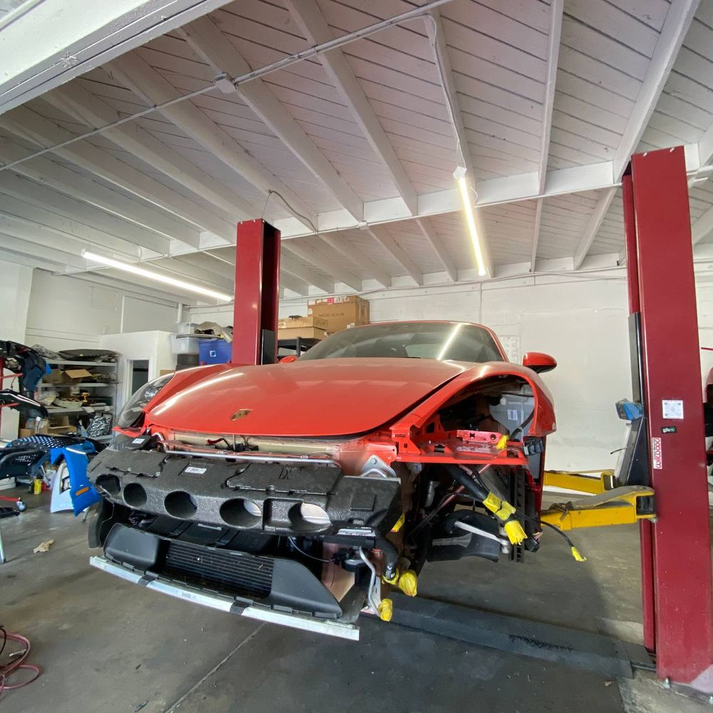 Porsche with front exterior components removed during collision work at Calibri Motorsport