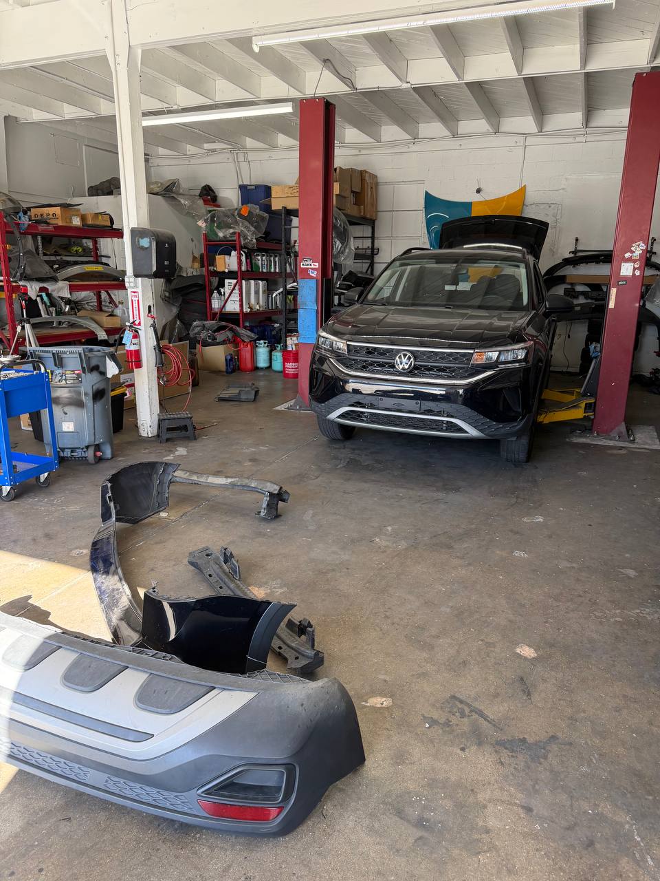Volkswagen Taos inside the collision shop with removed rear bumper components