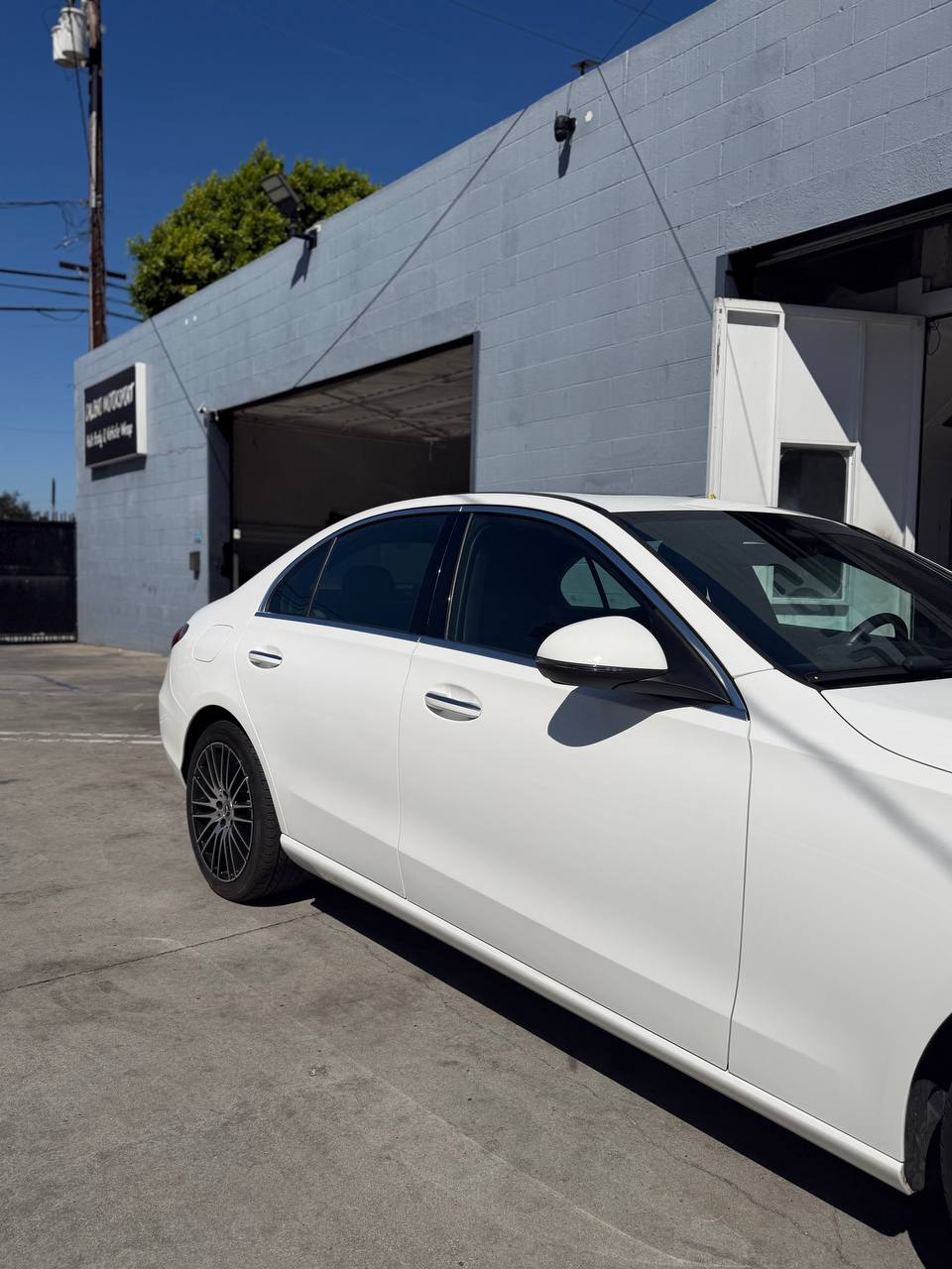 Finished front side of a white Mercedes-Benz C300 after collision repair