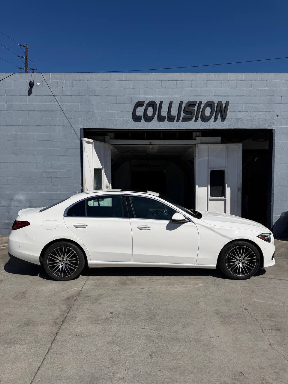 Repaired white Mercedes-Benz C300 outside the Calibri Motorsport collision center in Hawthorne