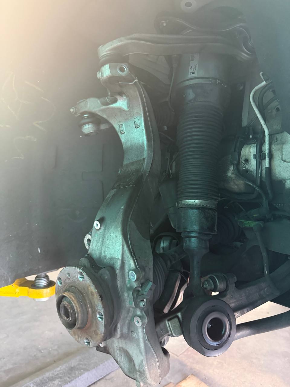 Front air strut and suspension components exposed on a Bentley sedan