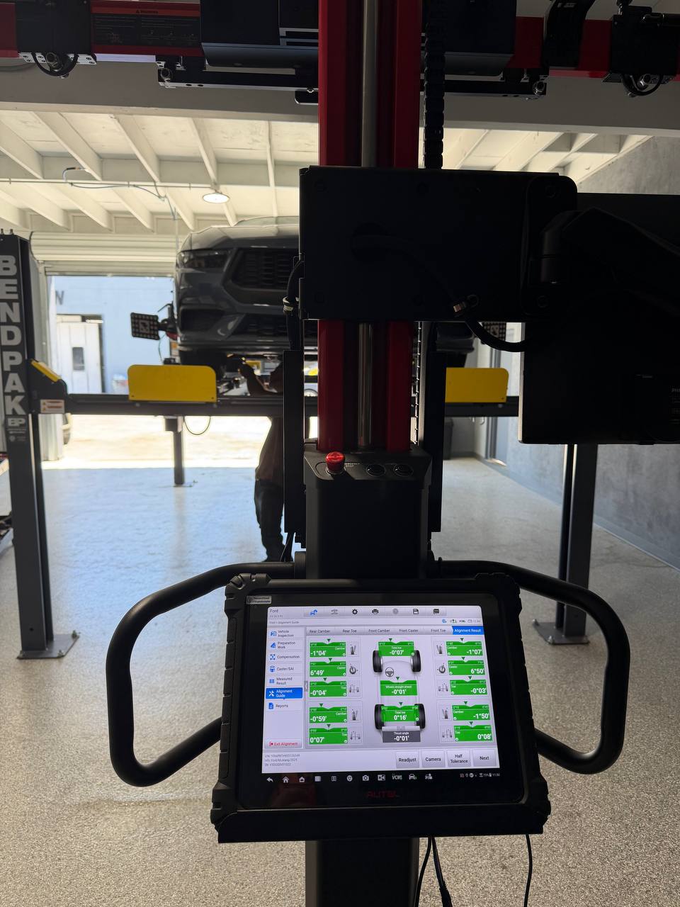 Ford Mustang on the rack with completed green alignment measurements displayed