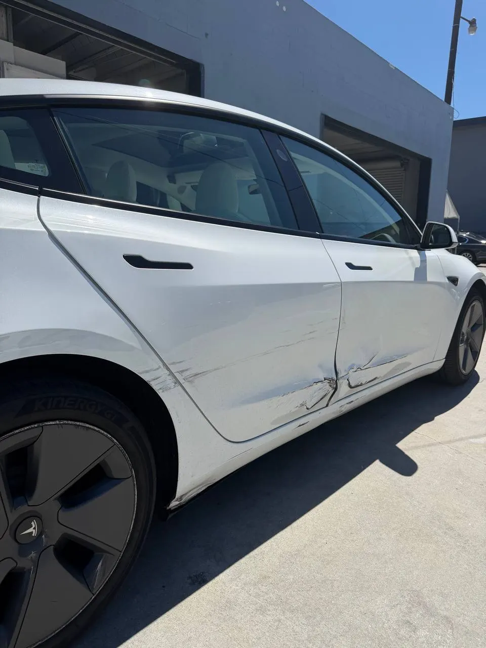 Lower door and rocker area of the damaged Tesla Model 3