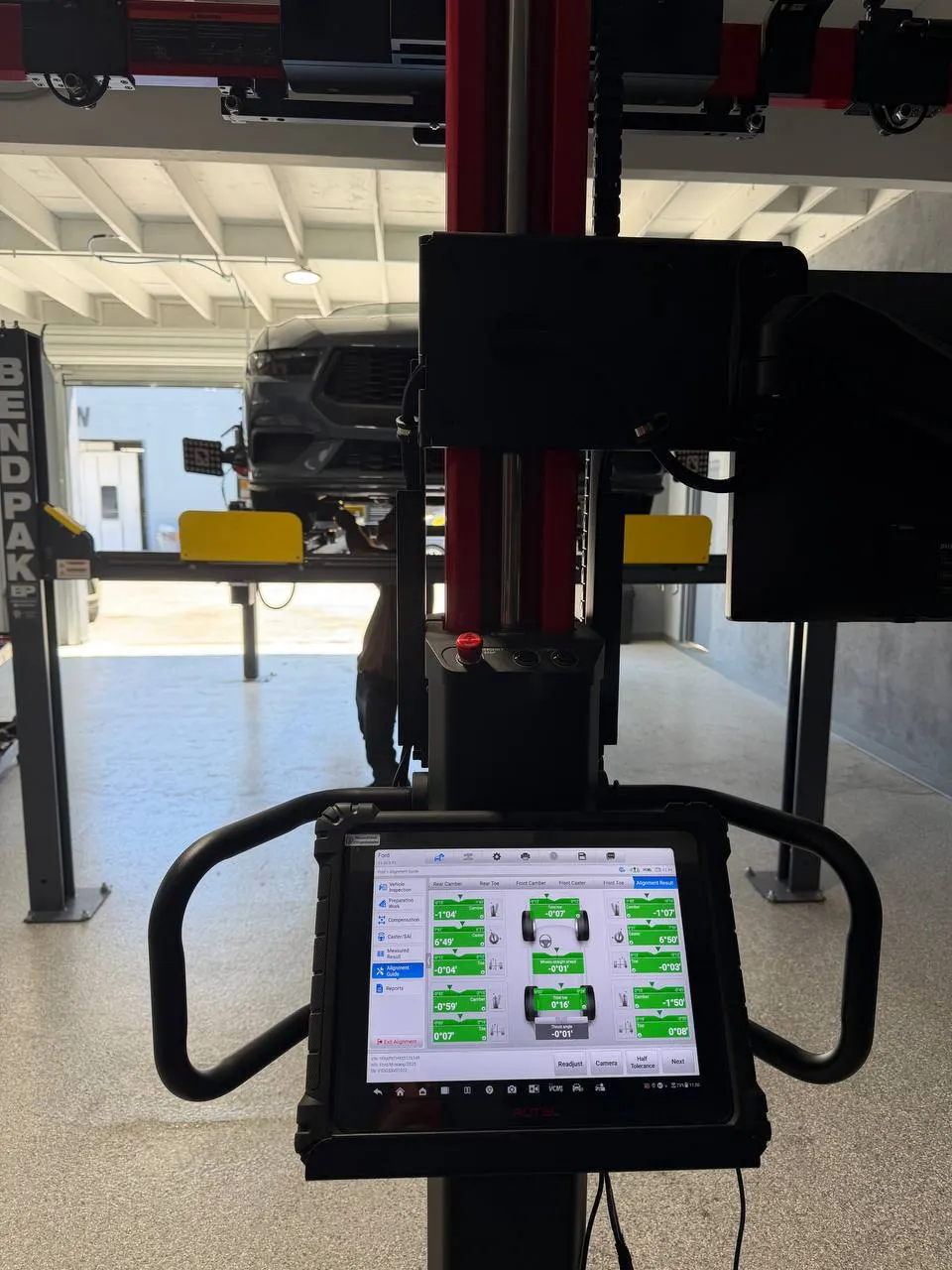 Ford Mustang on the rack with completed green alignment measurements displayed