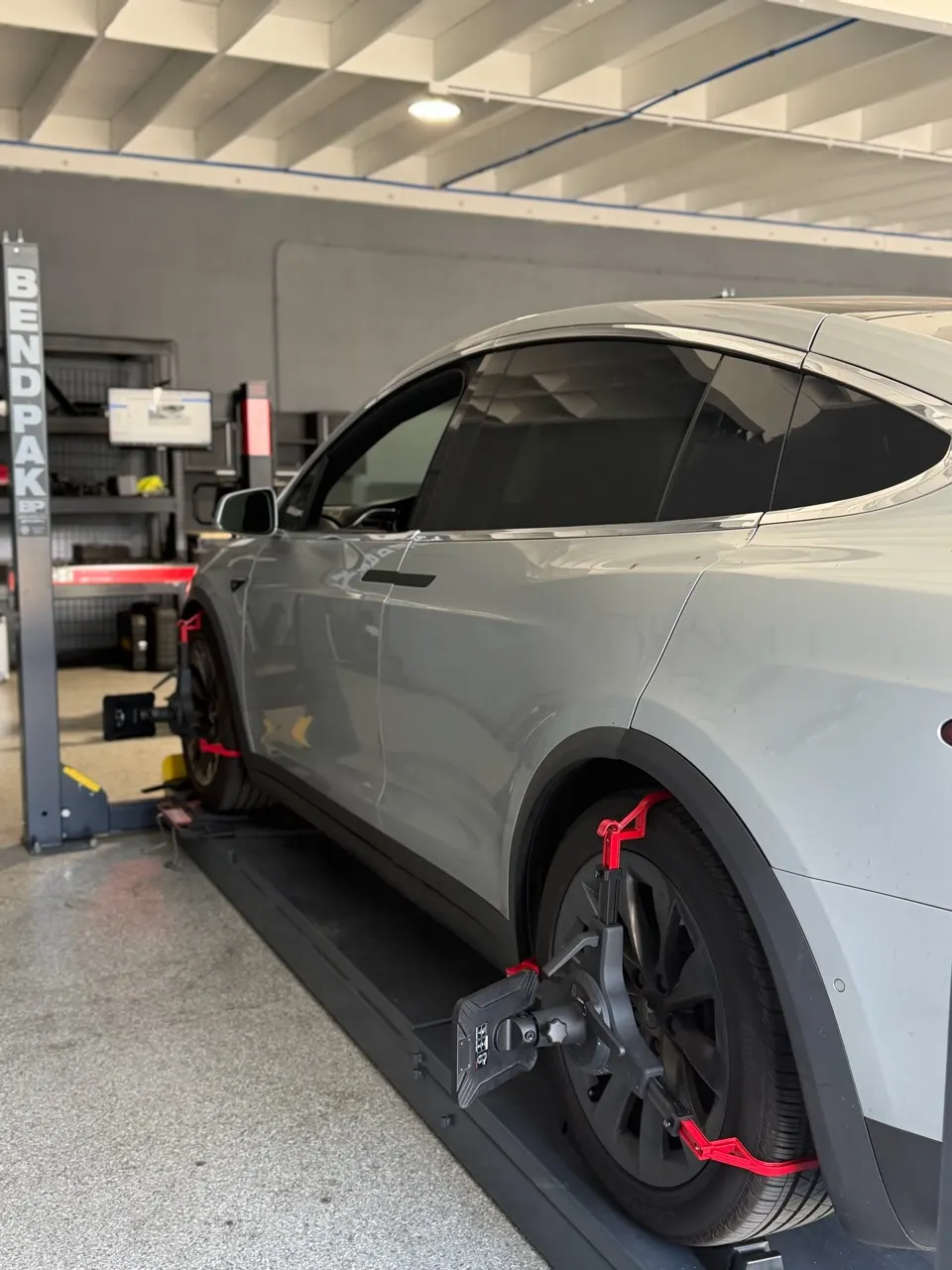 Tesla Model X on the wheel alignment rack with measuring targets attached