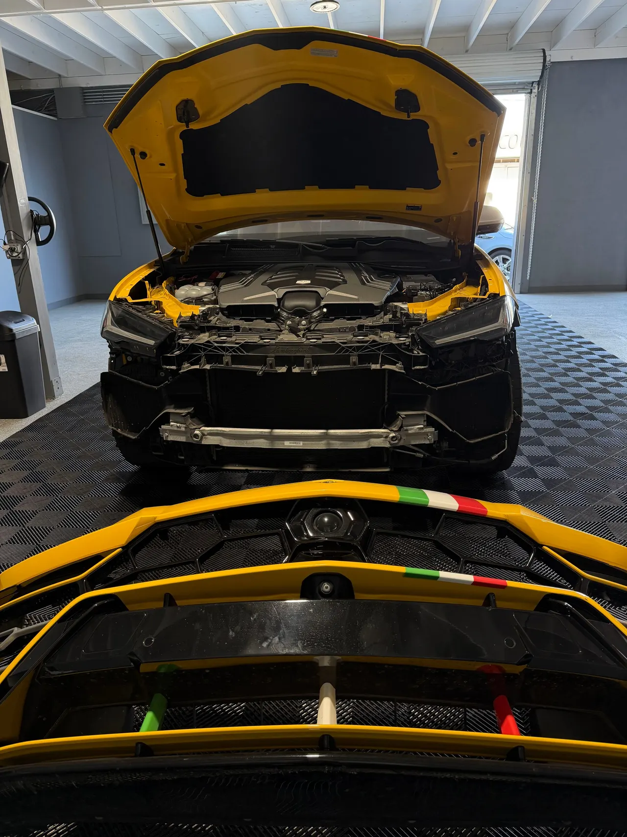 Front view of the Lamborghini Urus and its yellow bumper with black grilles and Italian tricolor stripes