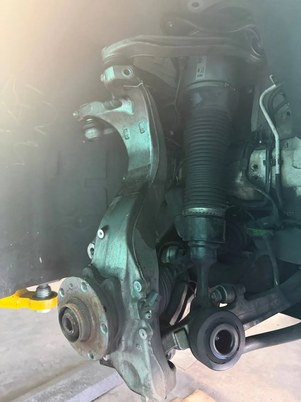 Front air strut and suspension components exposed on a Bentley sedan