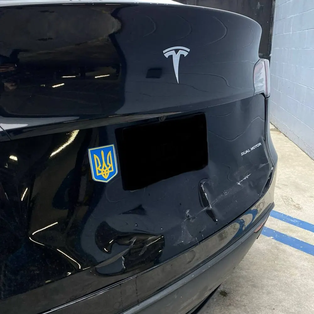 Rear exterior damage on a black Tesla Model Y before repair