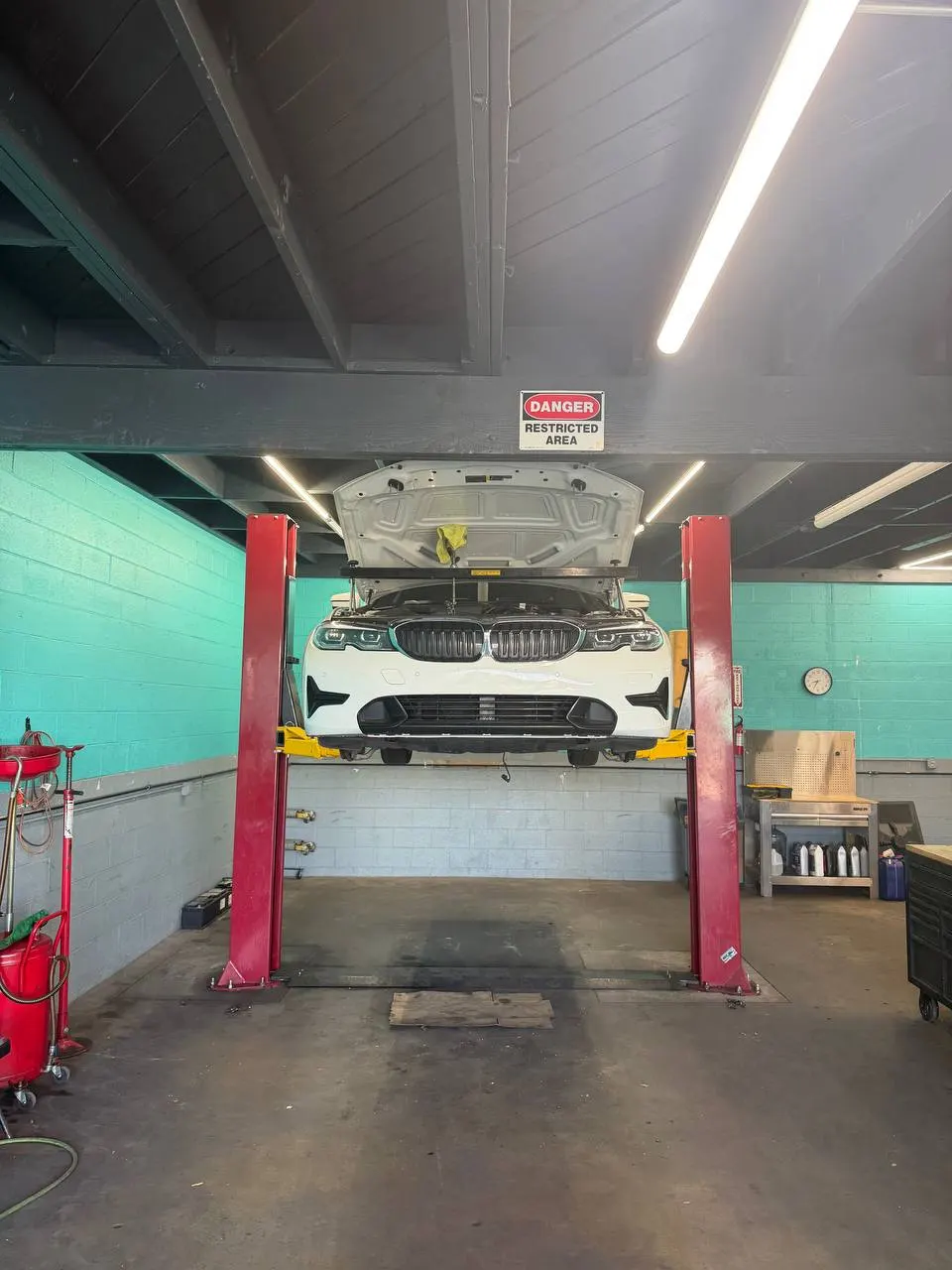 White BMW on a workshop lift with its hood open