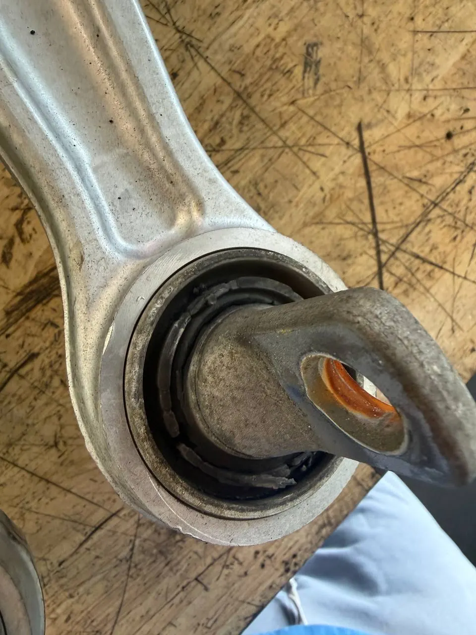 Close view of a worn Tesla Model 3 control-arm bushing removed during inspection