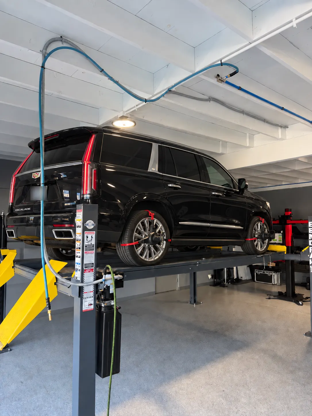 Illustrative Cadillac Escalade positioned on the Calibri Motorsport four-wheel alignment rack in Hawthorne
