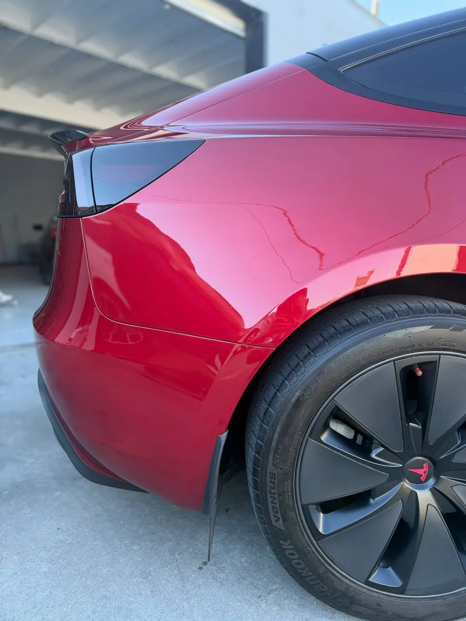 Close view of the finished red Tesla rear quarter and bumper