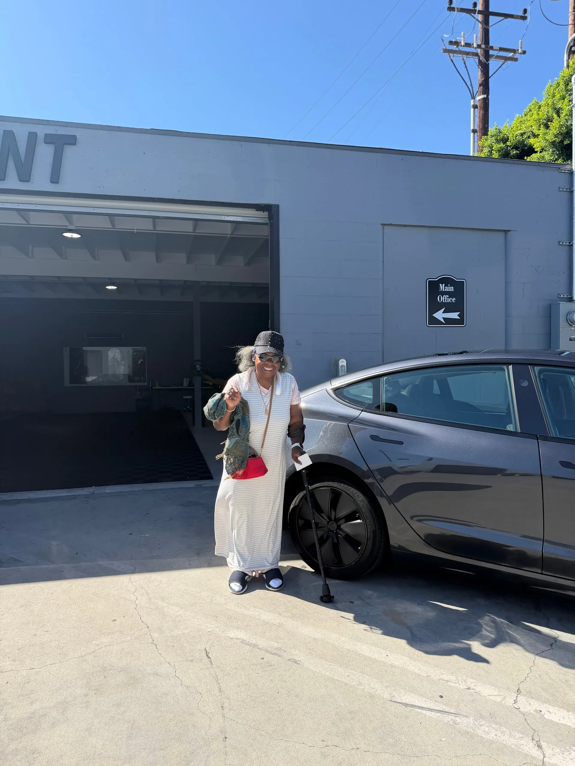 Customer beside a grey Tesla outside the Calibri Motorsport workshop