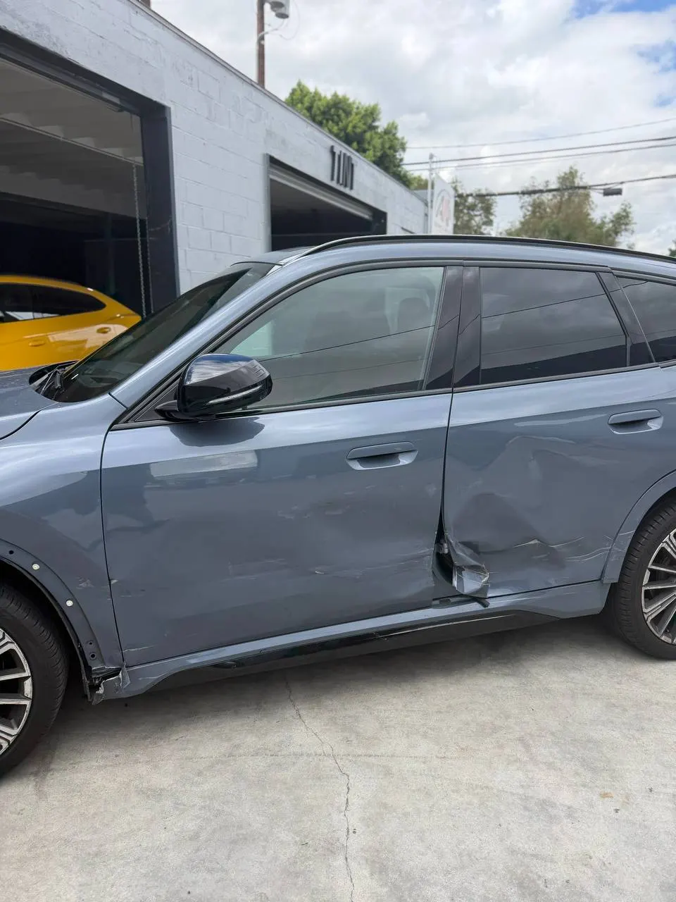 Visible impact damage across the left-side BMW X1 doors