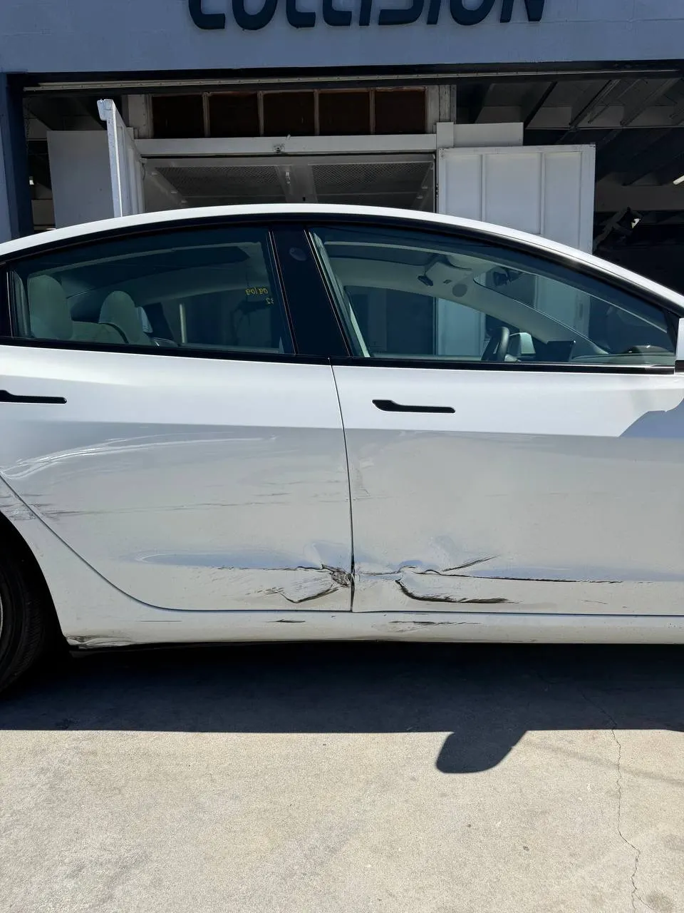 Close view of Tesla Model 3 door damage before repair planning