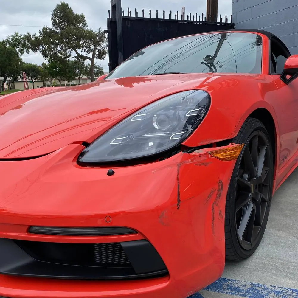 Porsche with visible front-left collision damage before repair at Calibri Motorsport