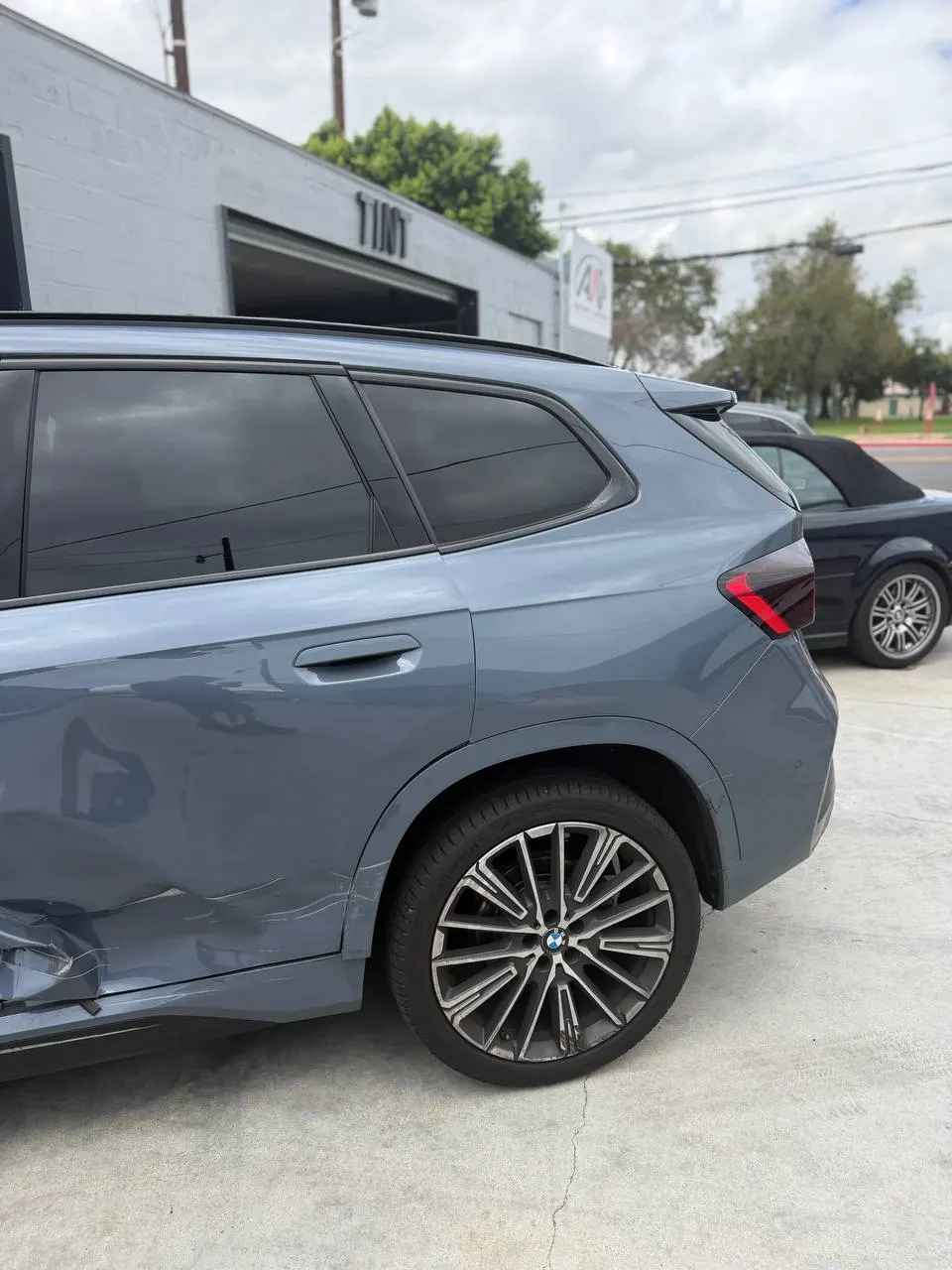 Damaged BMW X1 rear door beside the rear wheel